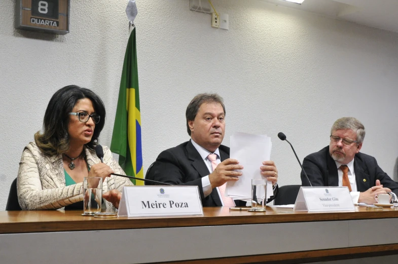 a group of people sitting at a table in front of flags