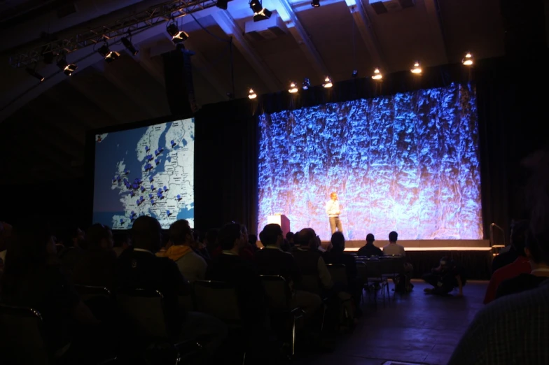 audience of people in large auditorium during a presentation