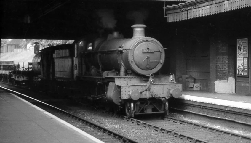 an old fashioned train at a station in black and white