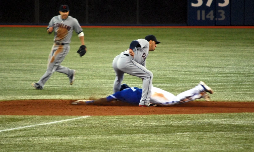 a baseball player sliding to home base and a catcher trying to catch the ball