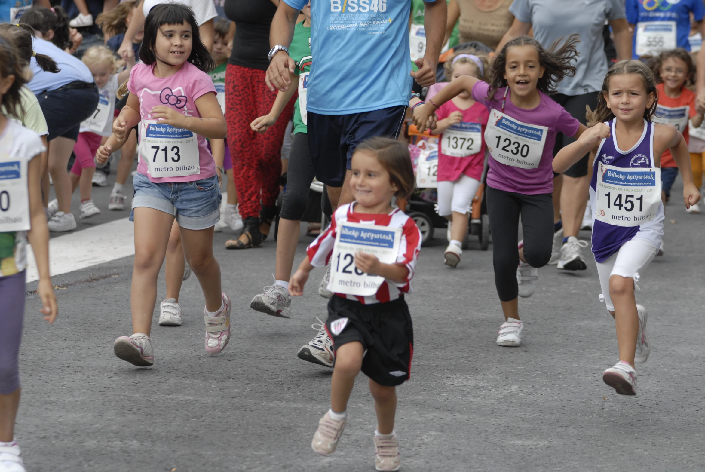 the little girls are racing each other down the street