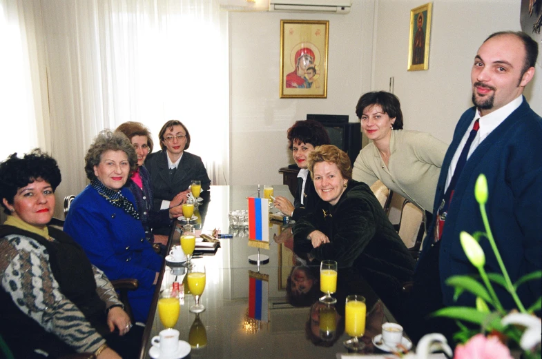 a group of people drinking orange juice on a dining room table