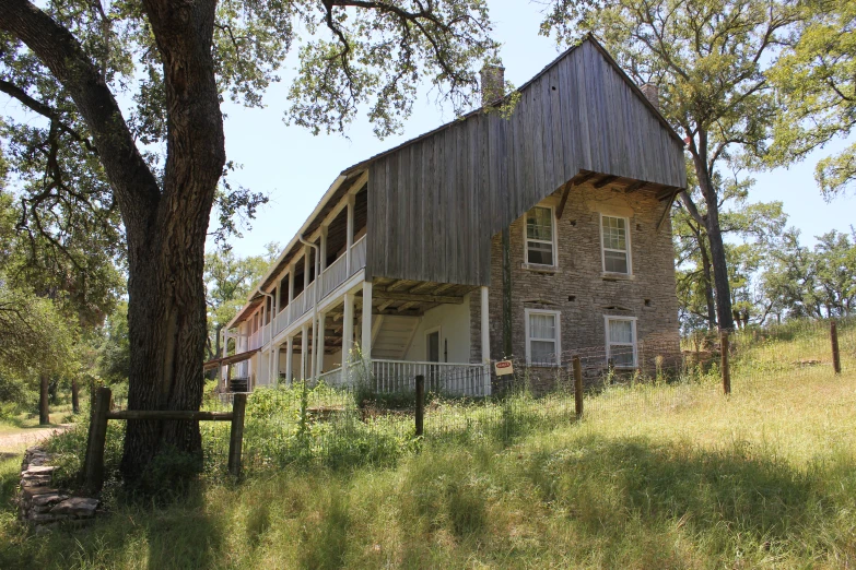 old wooden building with porchs in a field