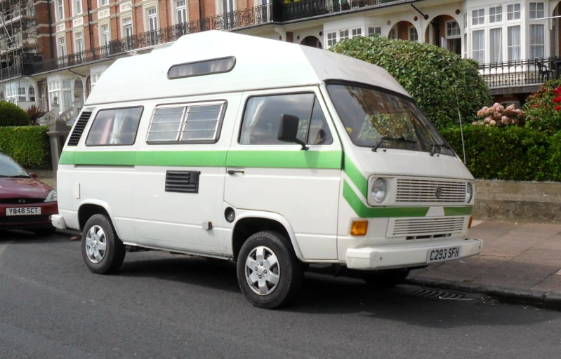 the small camper van has a green stripe on it's side