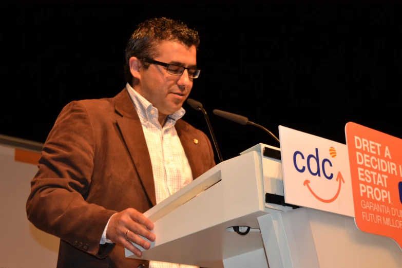 a man giving a speech in front of a crowd