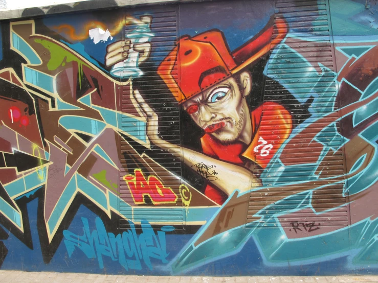 colorful graffiti on side of building with man wearing baseball hat holding up a beer