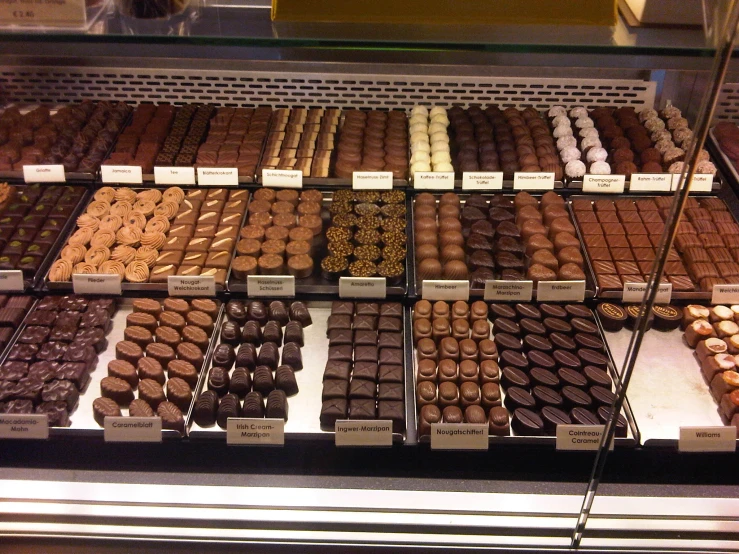 chocolates are displayed behind the glass in this display case