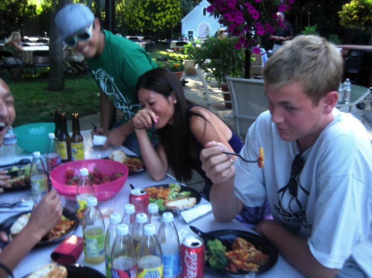 five young people eating dinner at a table