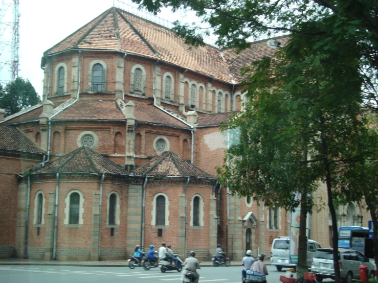 there is a large building next to people on bicycles