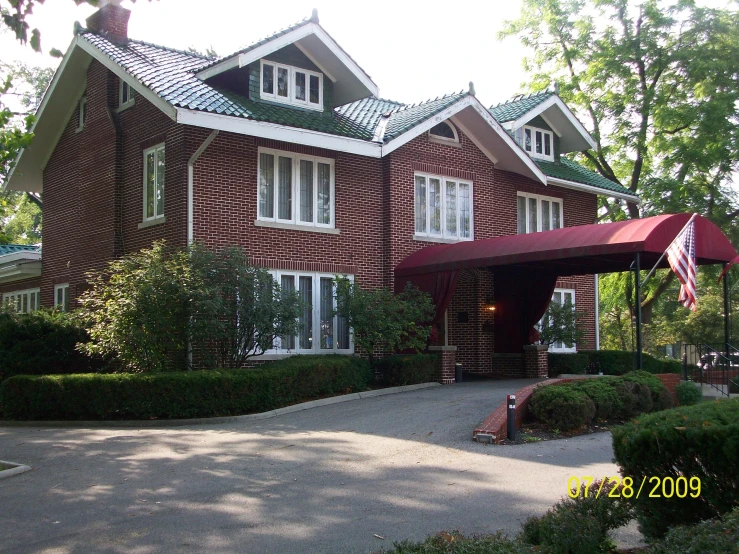 a large red brick house with a red awning