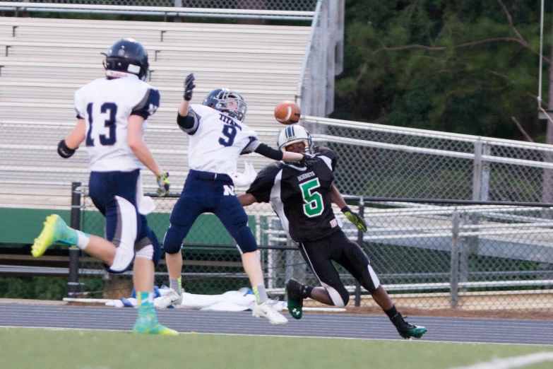 the football player is jumping to catch the ball