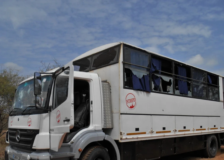 a white double decker bus is in the field