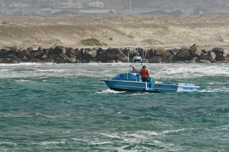 a man stands on the front of a fishing boat in rough seas