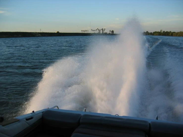 a boat with a wake and a spray shooting out the water