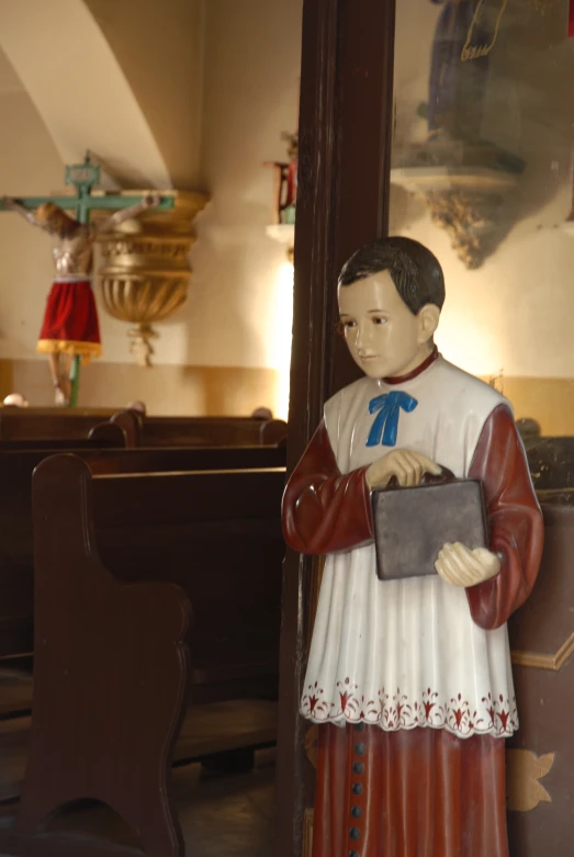 a statue stands next to a wall with shelves