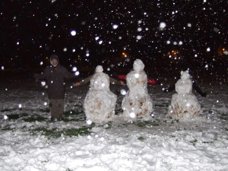 a snowman with snow around it near a person