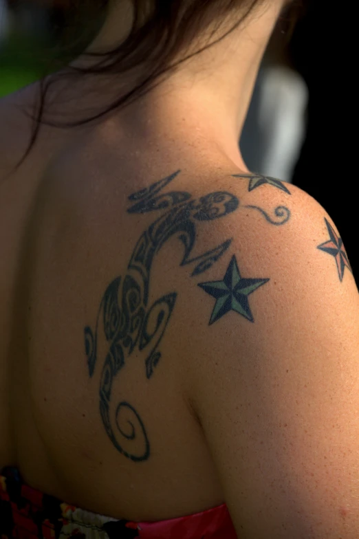 woman with tattoos standing with the sun behind her back