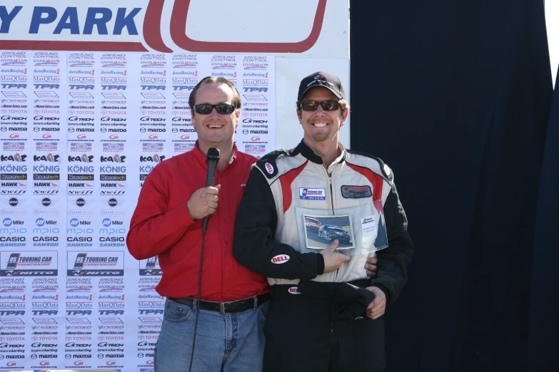 two men standing together and one giving the peace sign