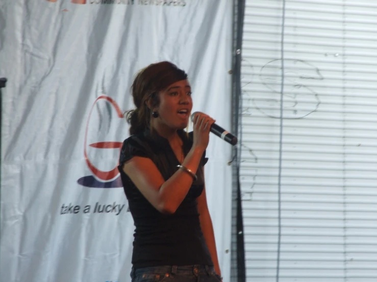 a young woman in black shirt holding a microphone