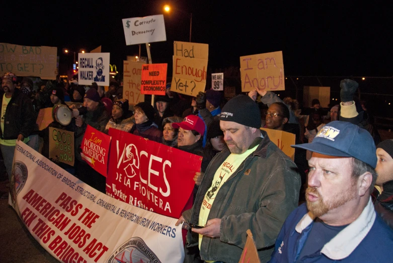 a crowd of people holding signs in the dark