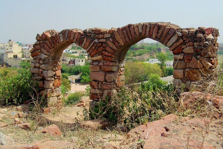 two stone arches are seen near some buildings