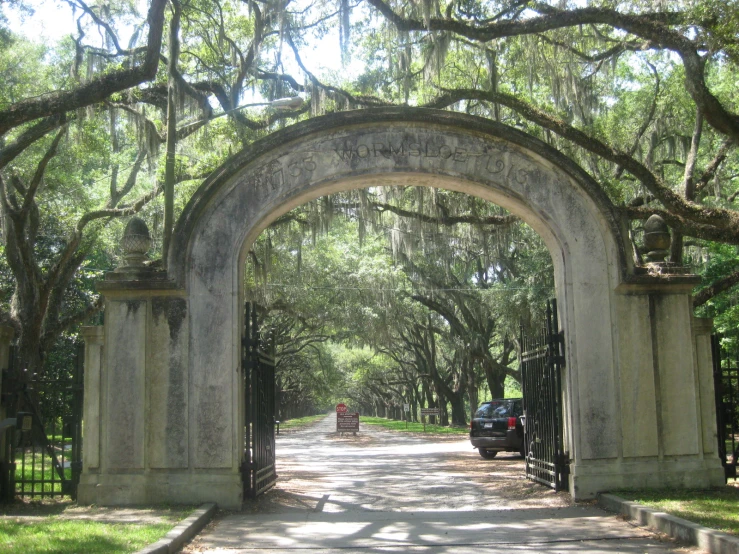 a beautiful old gate is covered with live trees