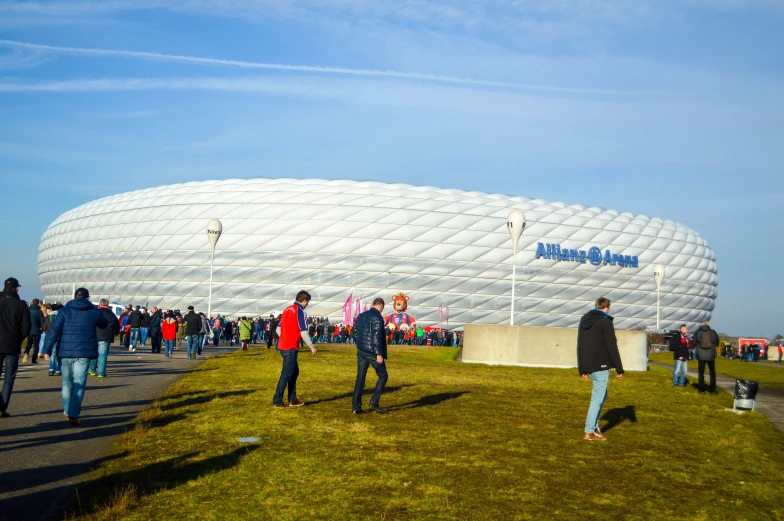 a crowd of people are walking in front of a soccer stadium