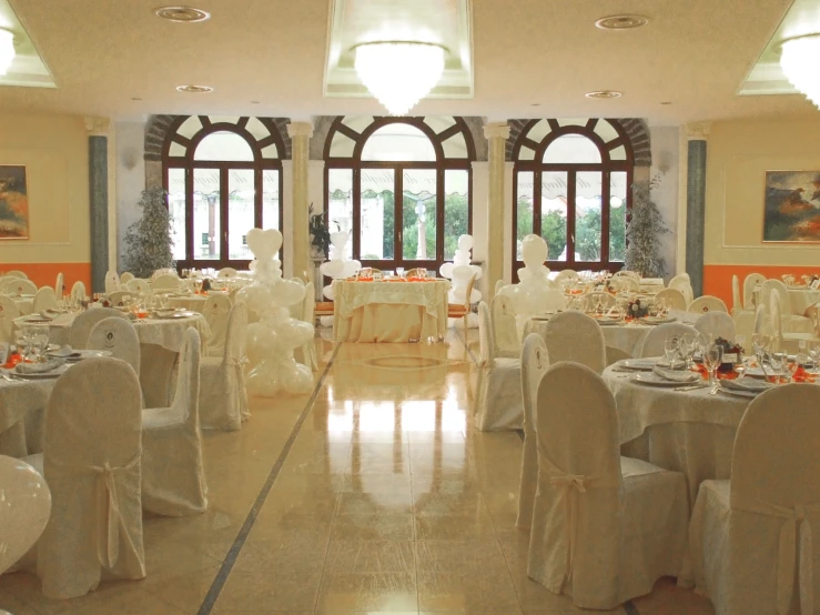 rows of chairs are set for formal dining in this large room