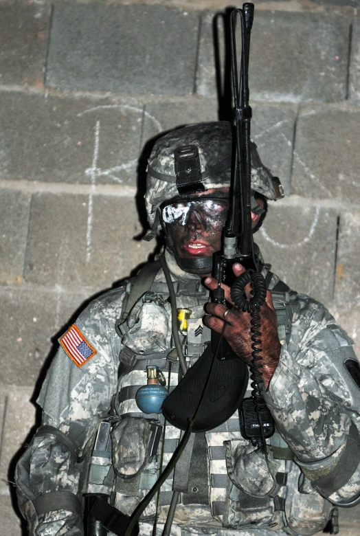 a man in military gear holds up a gun