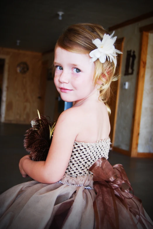 a little girl wearing a flower and dress