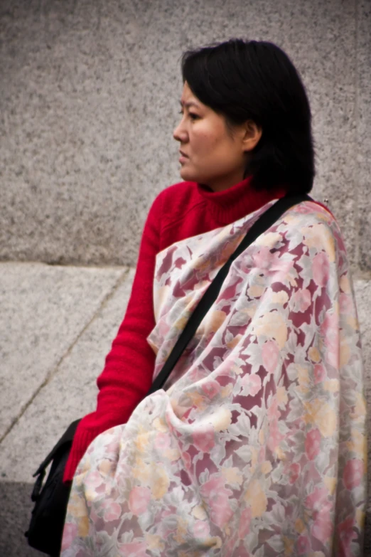 a woman sitting on top of a cement wall