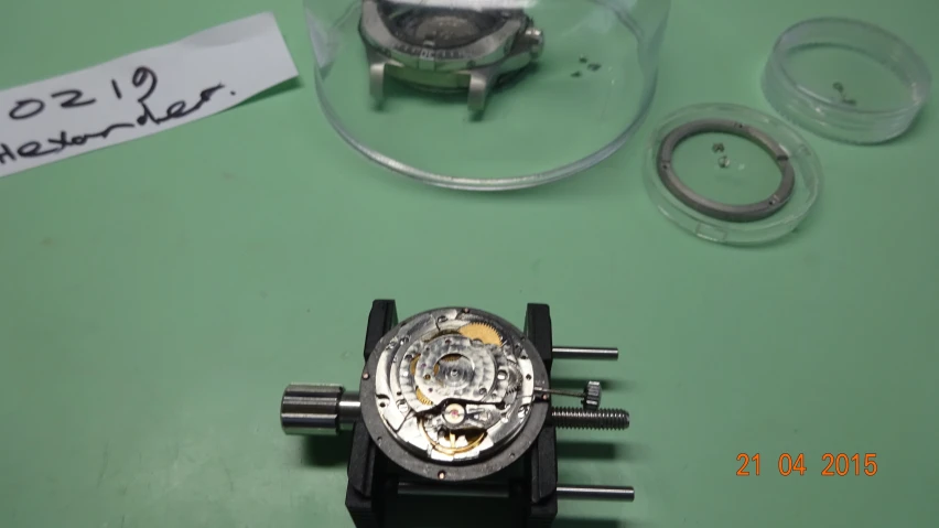 an automatic watch is set inside of a glass dome