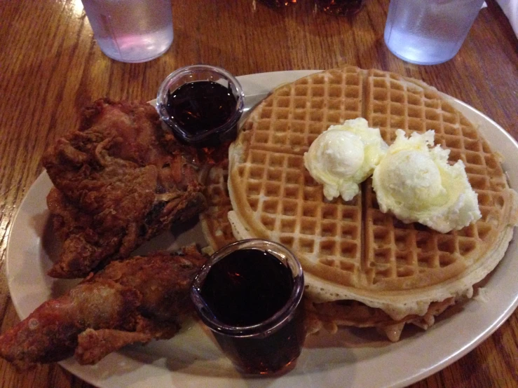 chicken, waffles and sauce are on a plate
