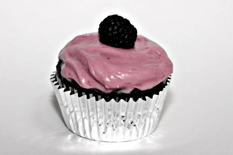 a cupcake with frosting and blackberries in the top