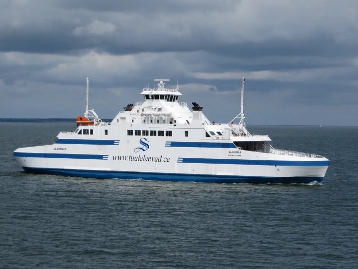 white and blue ferry boat traveling across calm ocean waters