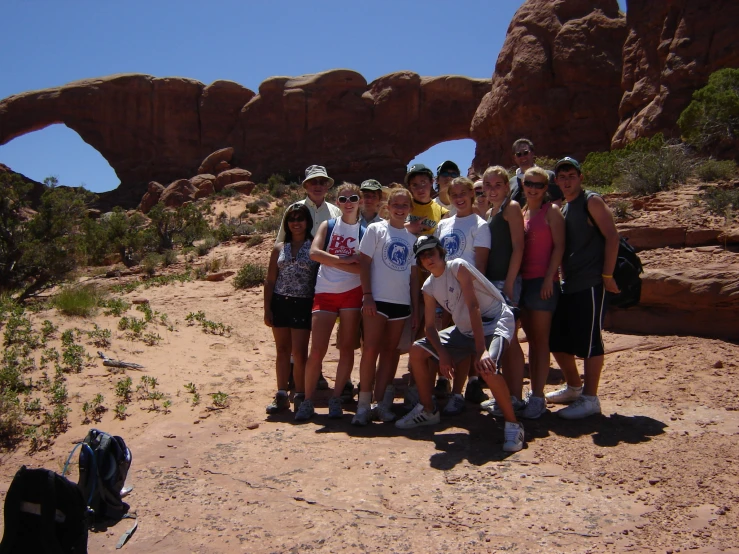 a group of people pose for a picture on some sand