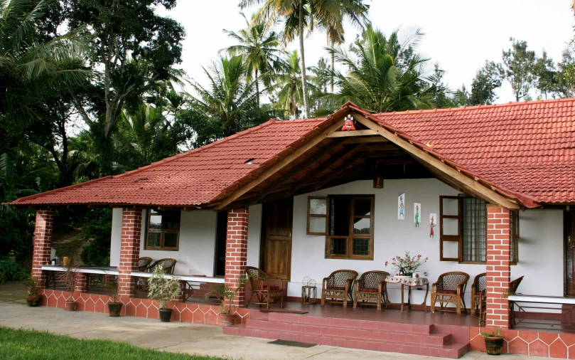 a building with several chairs sitting outside and trees