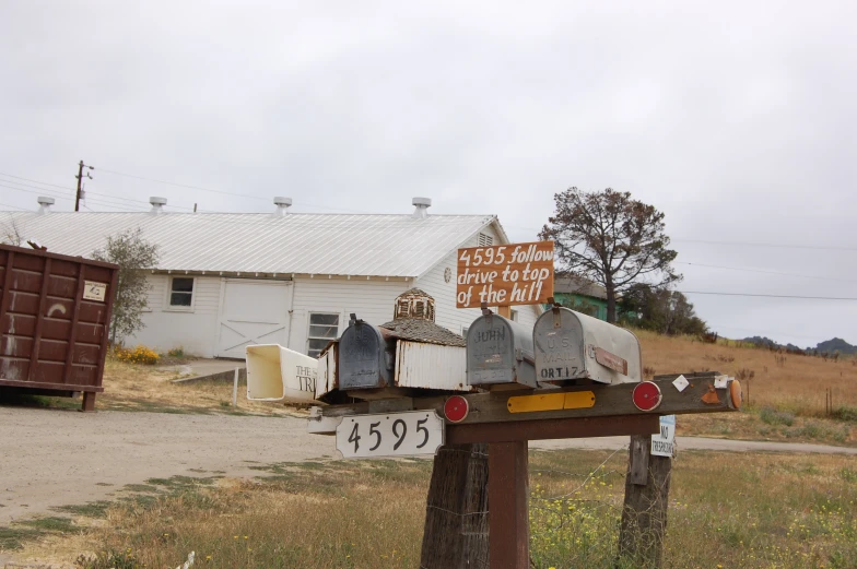 many mailboxs are placed on top of a wooden post