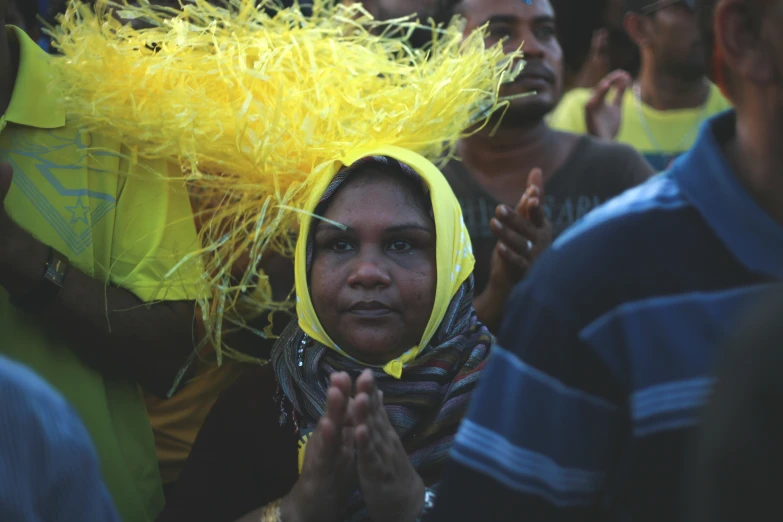 a woman is dressed in yellow and a crowd watches her