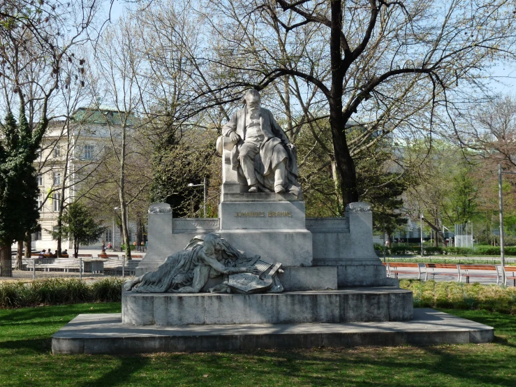 a statue sitting in the middle of a lush green field