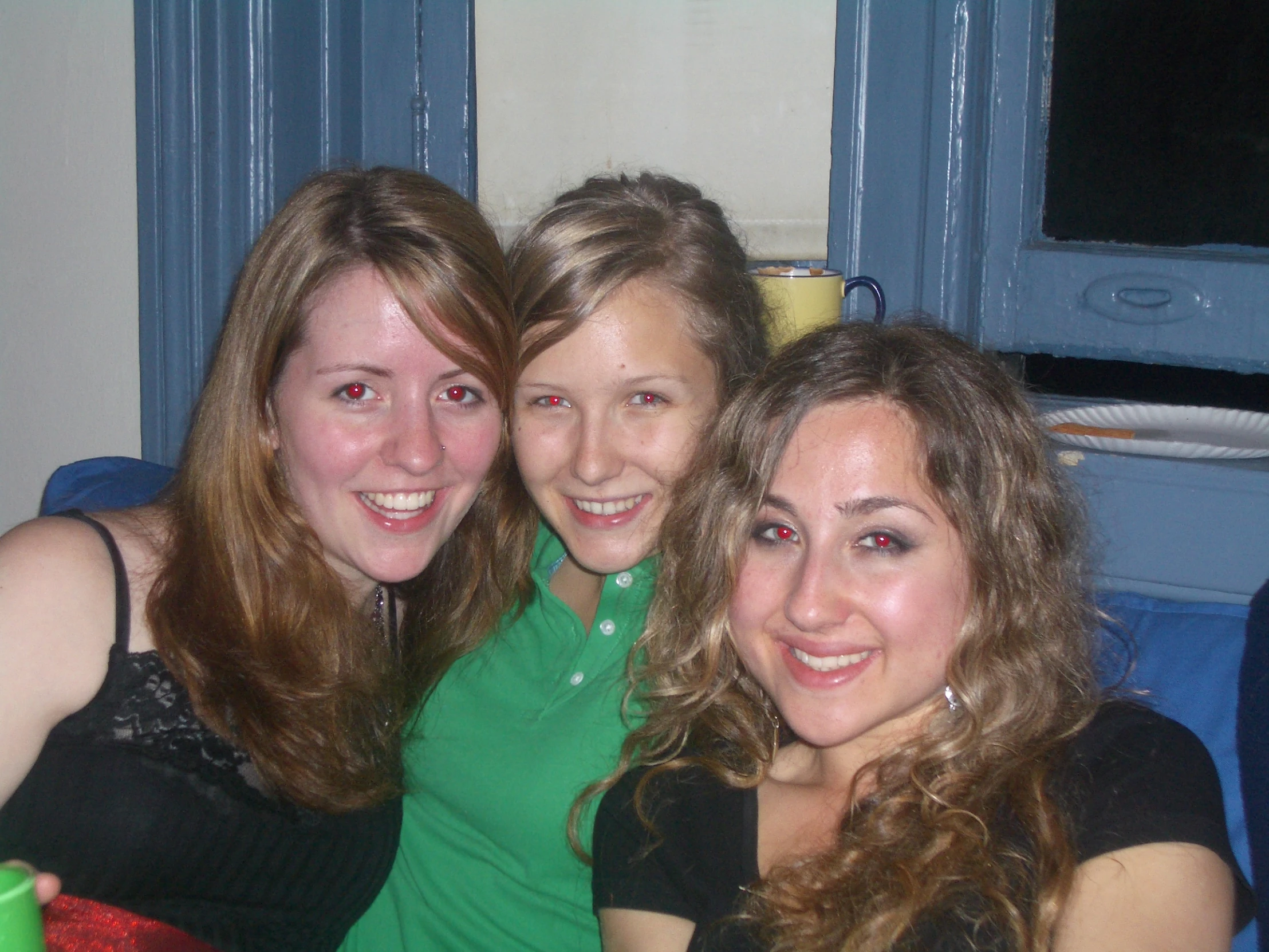 three girls are sitting together smiling for the camera