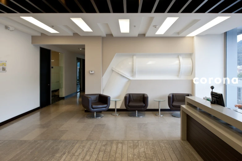 the lobby of an office with two chairs and a table