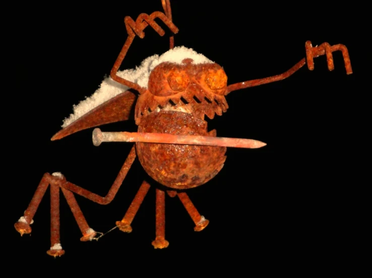 a rusted metal sculpture of a person holding a pencil