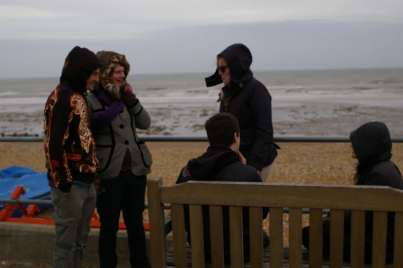 people talking on cell phones near the beach