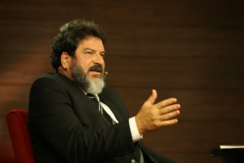 an old man wearing a suit and tie sitting down