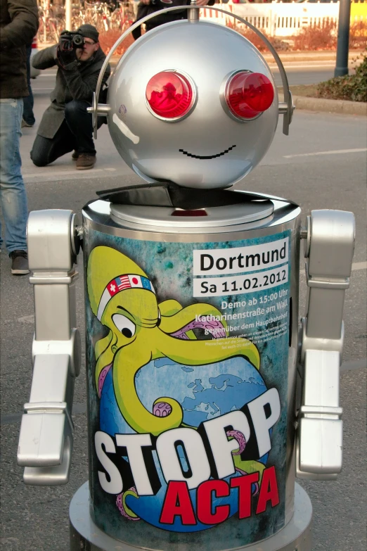 a robot like creature with a surprised face is parked near a curb