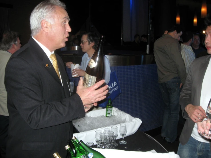 man standing with a bottle of wine in his hand