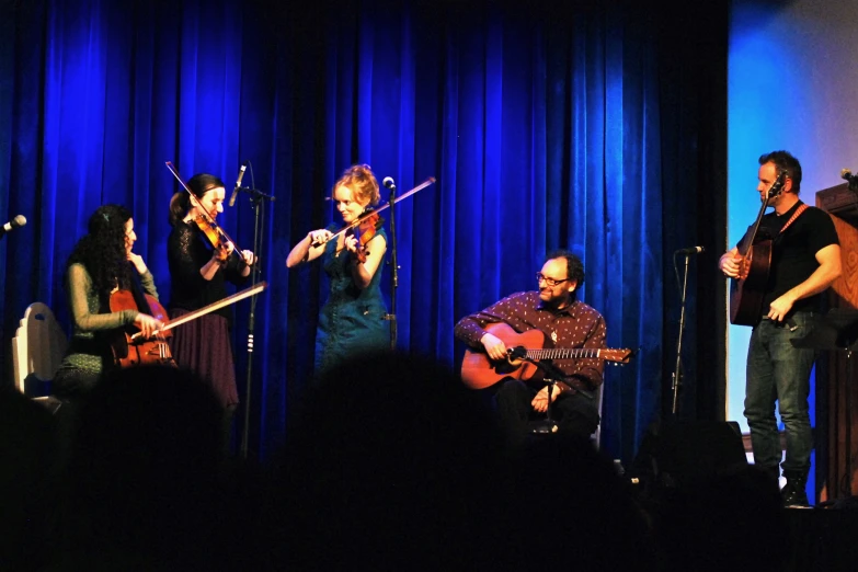 a band of people are playing on a stage