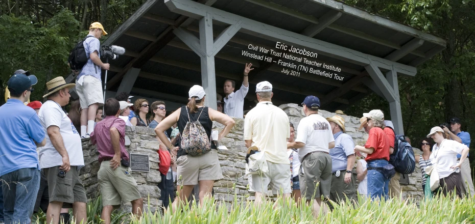 people in a group around rocks outside an outdoor structure