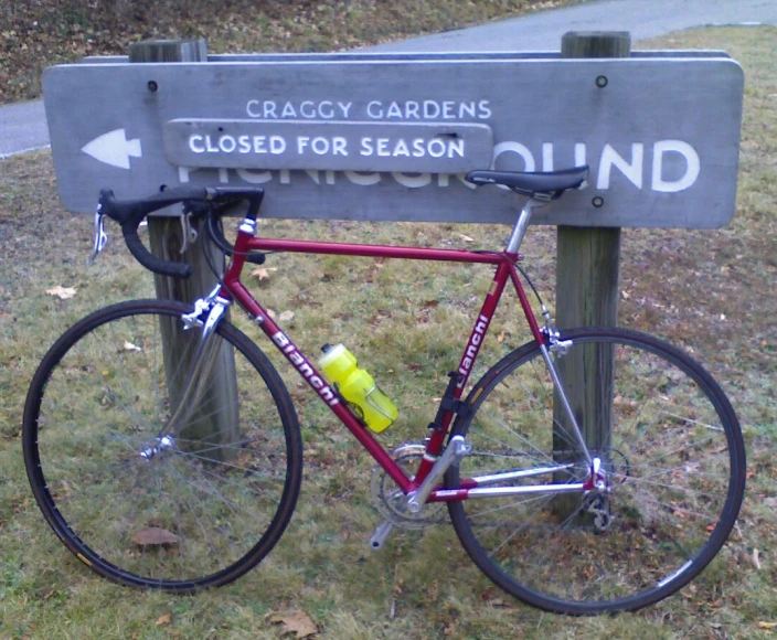 a red bicycle sits in front of a sign